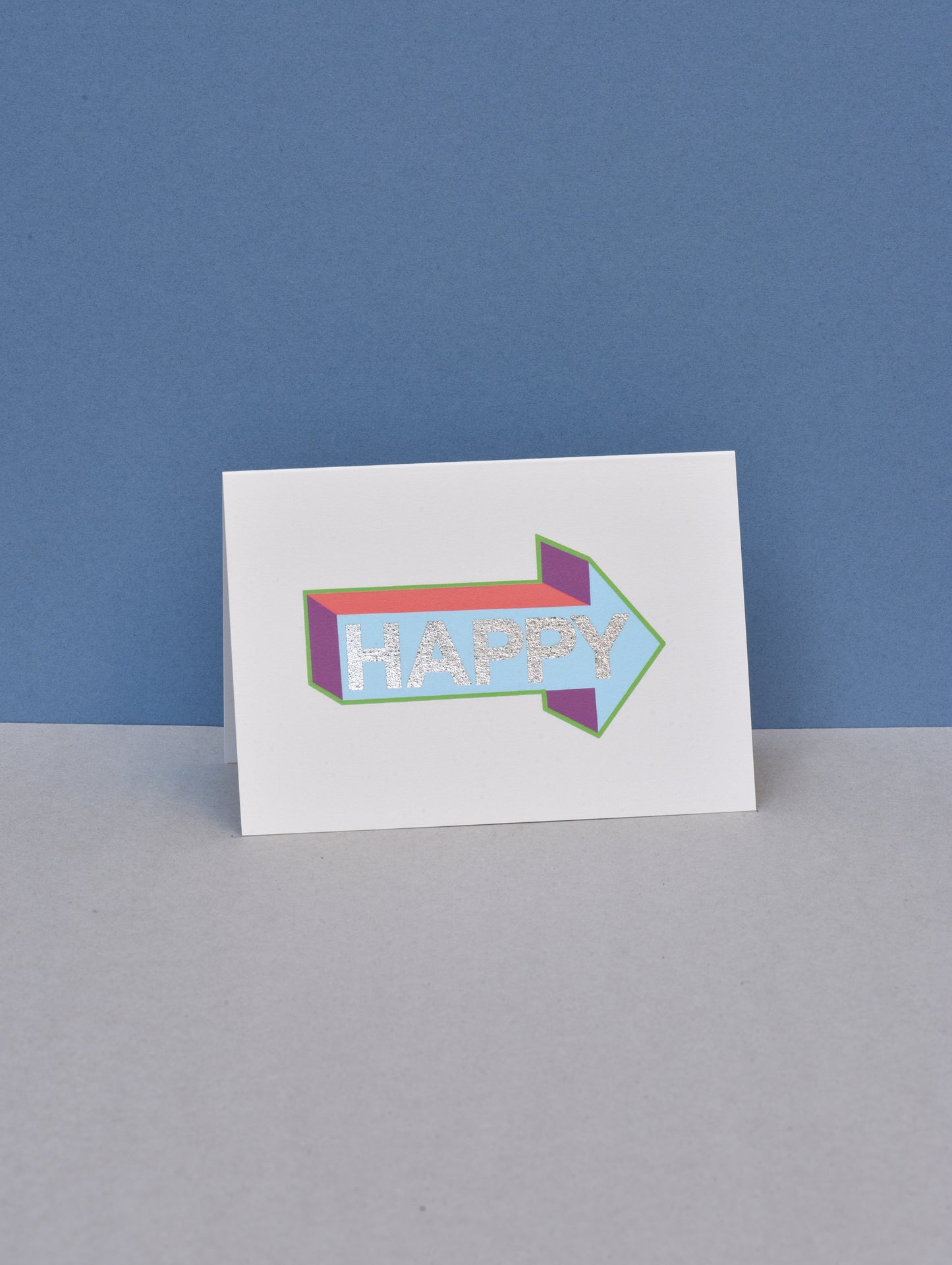 Card with a colorful arrow-shaped design and 'Happy' text on a blue and gray background