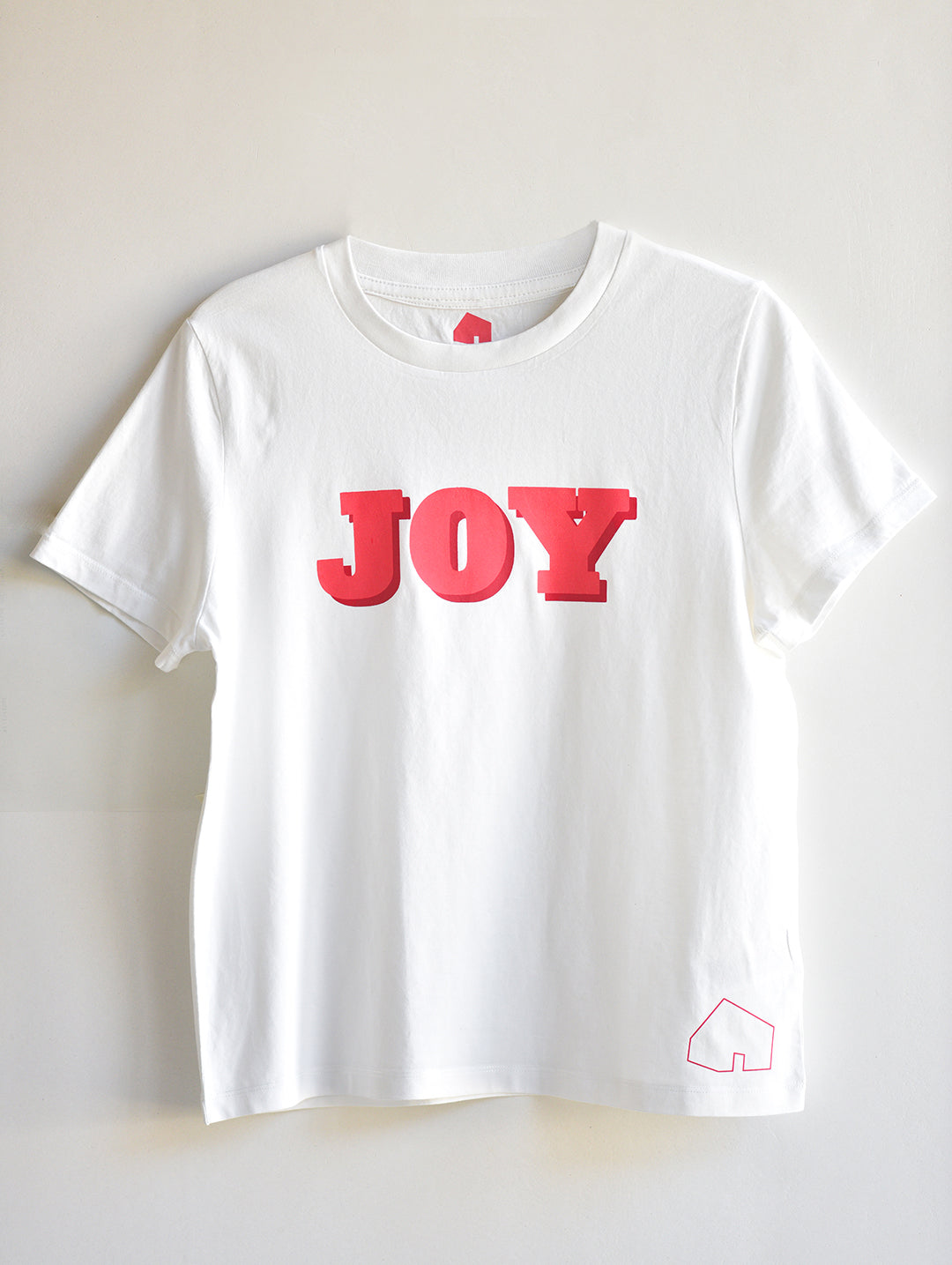 White t-shirt with red 'JOY' text on a light gray background