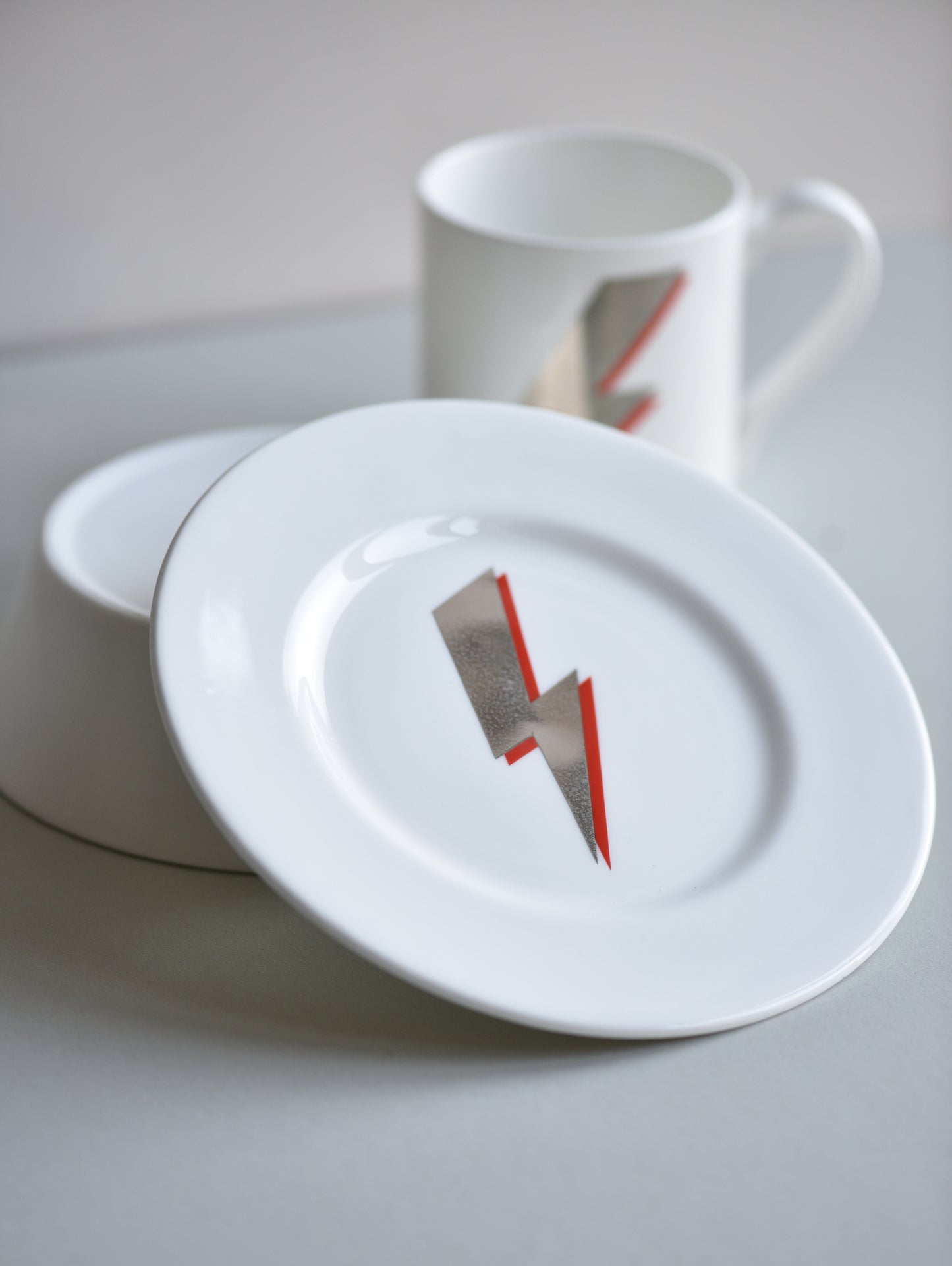 White ceramic plate with a lightning bolt design on a light gray surface