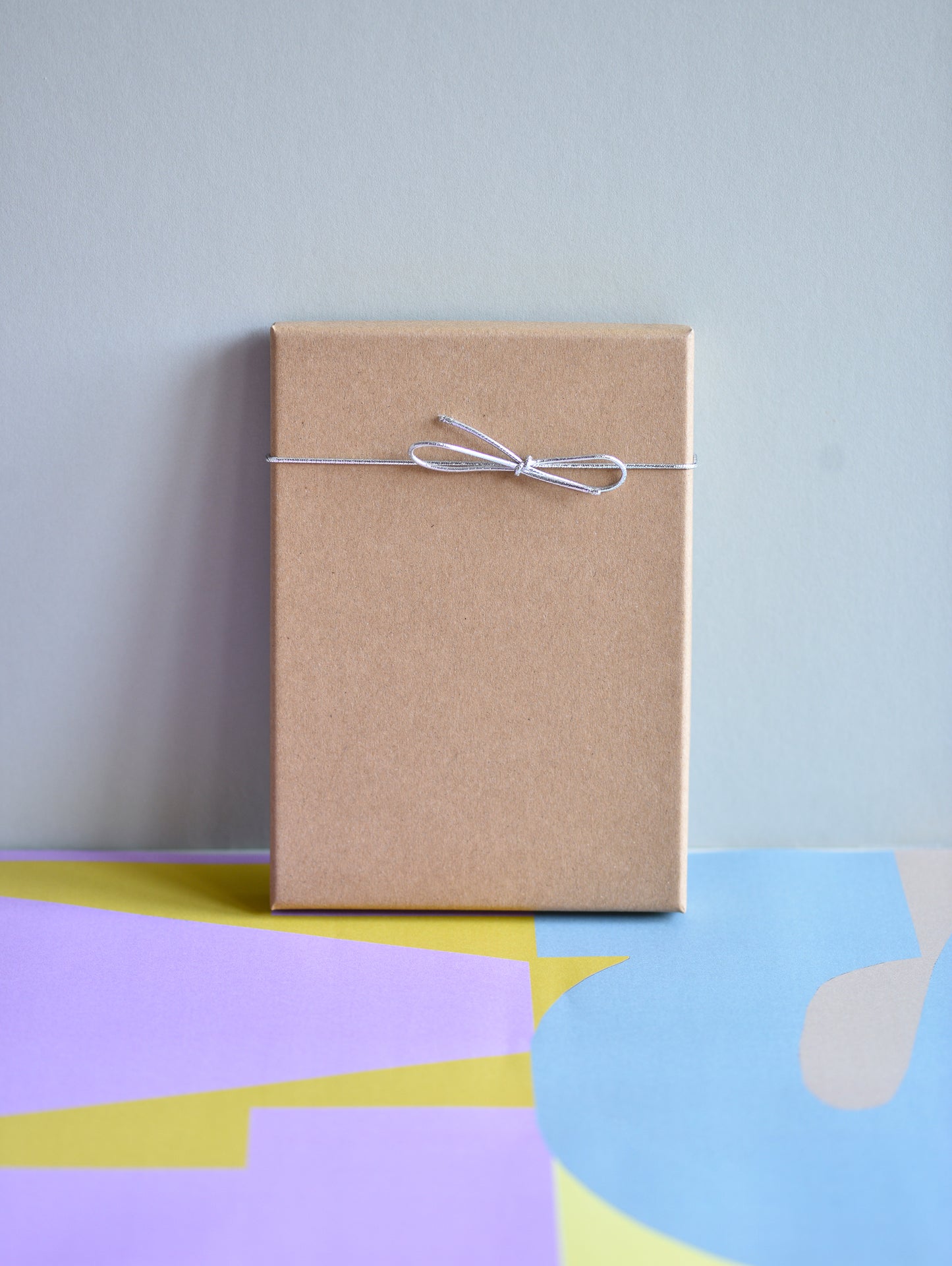 Brown paper package tied with string on a colorful abstract background