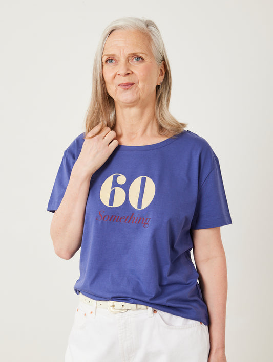 Woman wearing a blue t-shirt with '60 Something' text on a plain background