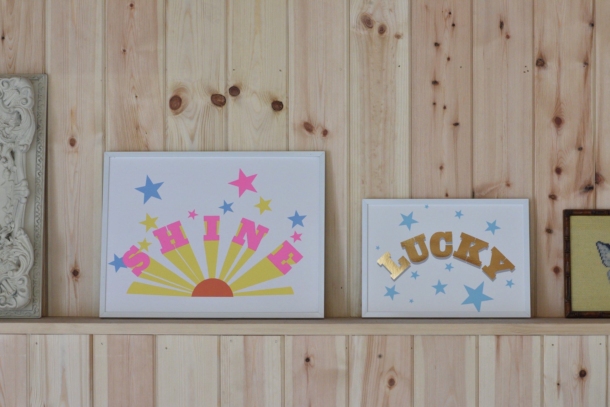 Decorative signs with 'SHINE', 'LUCKY', and star designs on a wooden shelf.