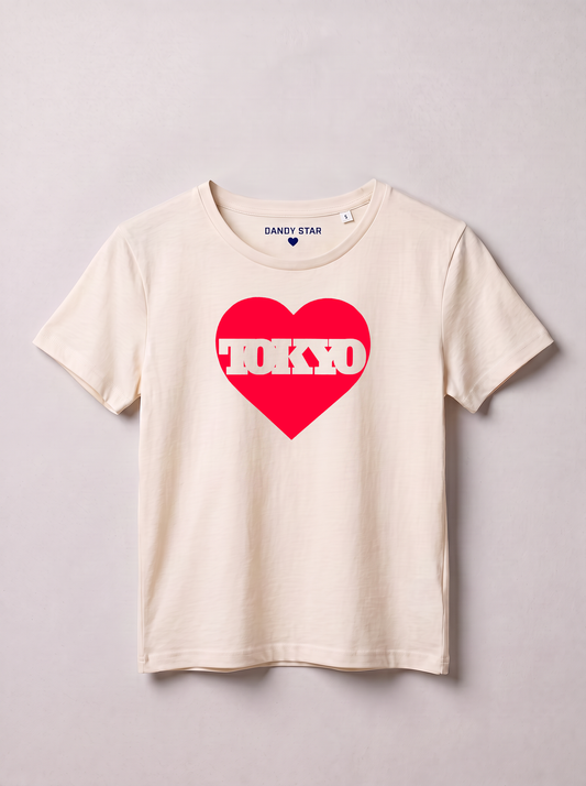 A cream-colored short-sleeve t-shirt with a red heart graphic on the chest containing the word 'TOKYO' in white. The inner neck label shows the brand 'DANDY STAR'.