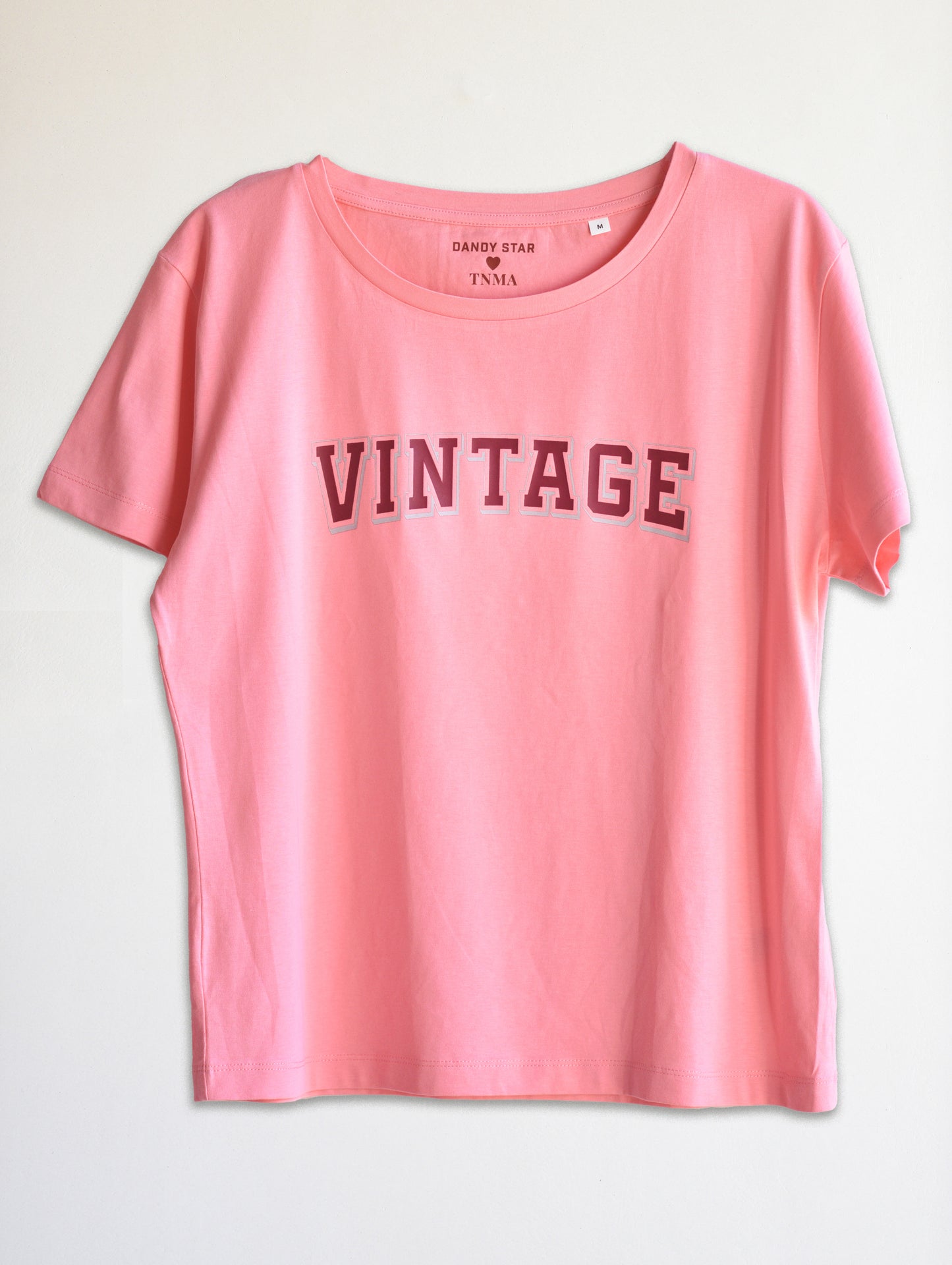 Pink t-shirt with 'VINTAGE' text on a light gray background