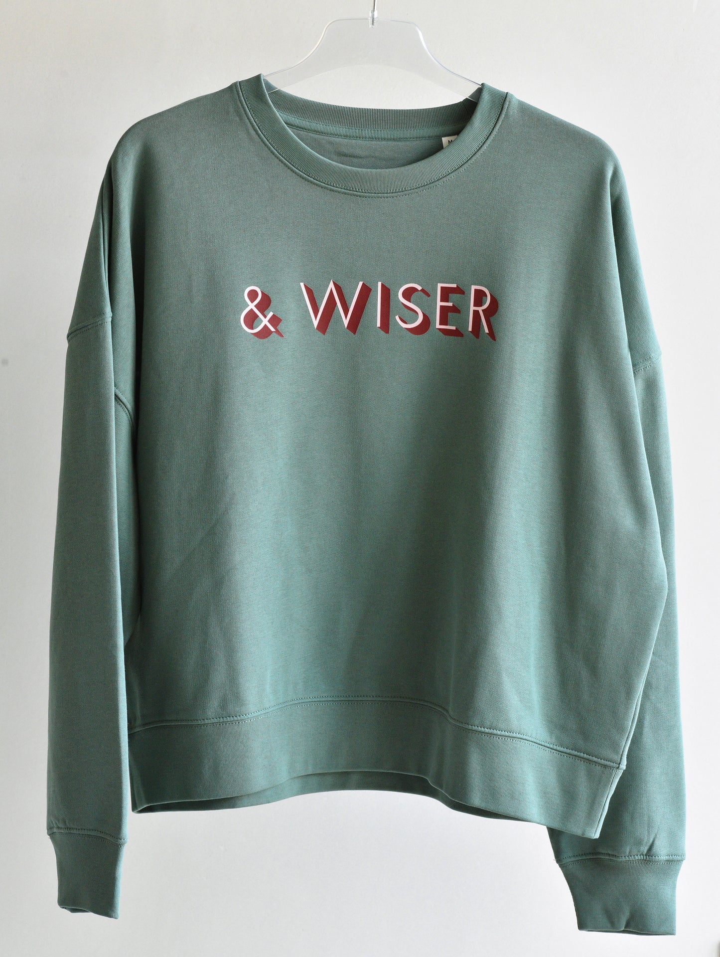 Green sweatshirt with 'WISER' text on a white background