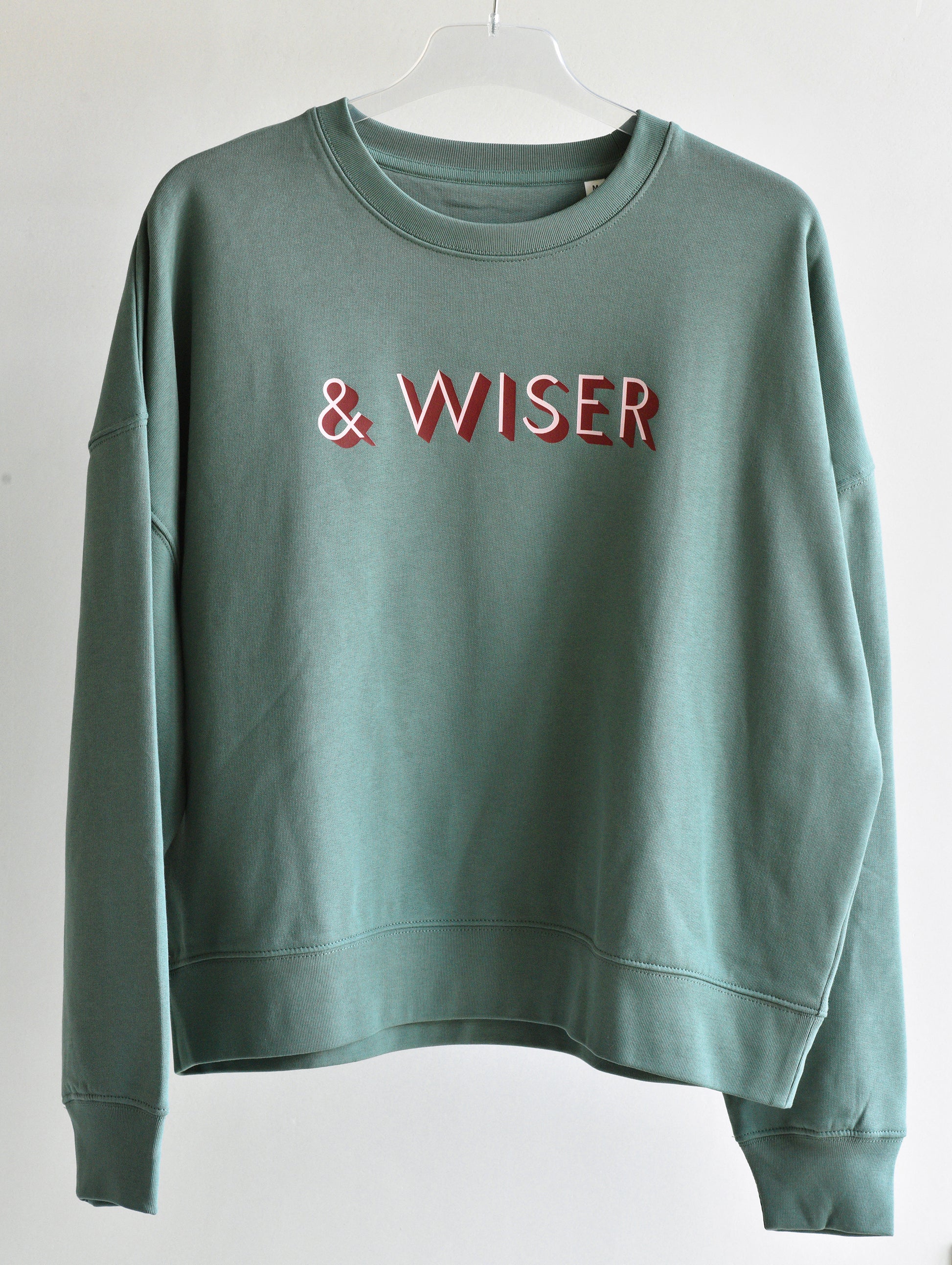 Green sweatshirt with 'WISER' text on a white background