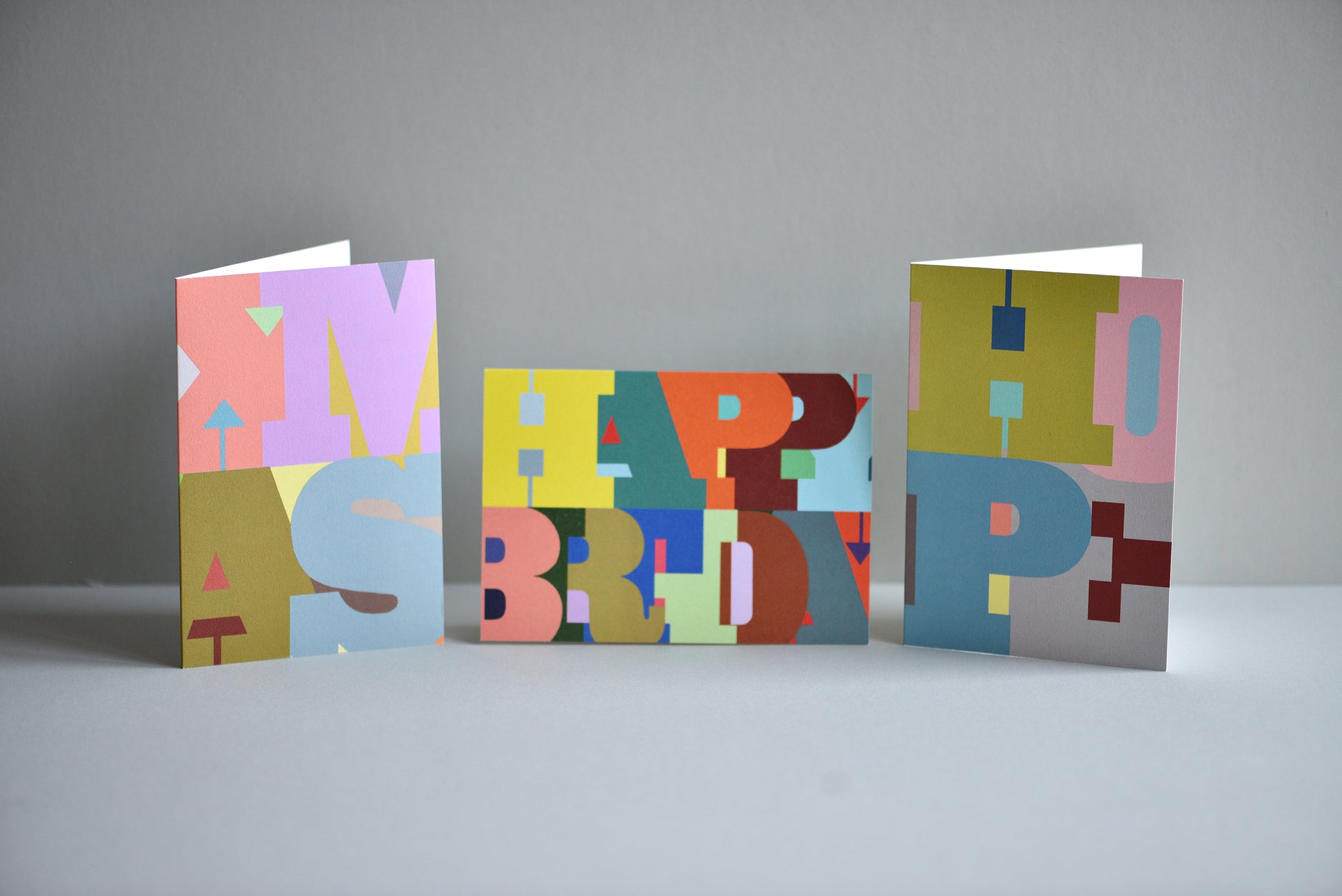 Three colorful birthday cards with 'Happy Birthday' text on a gray background