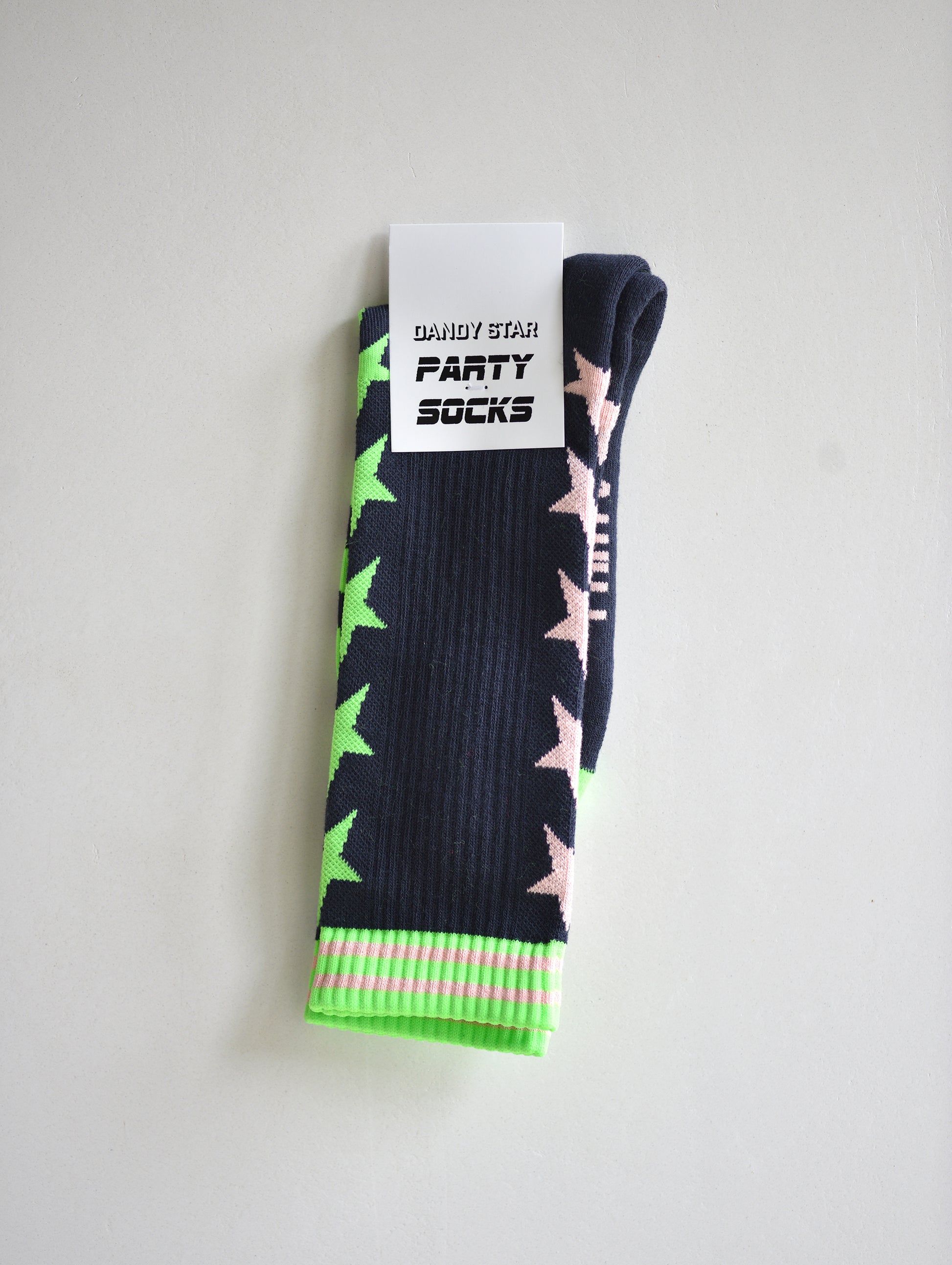 Pair of black socks with pink and green star patterns on a white background