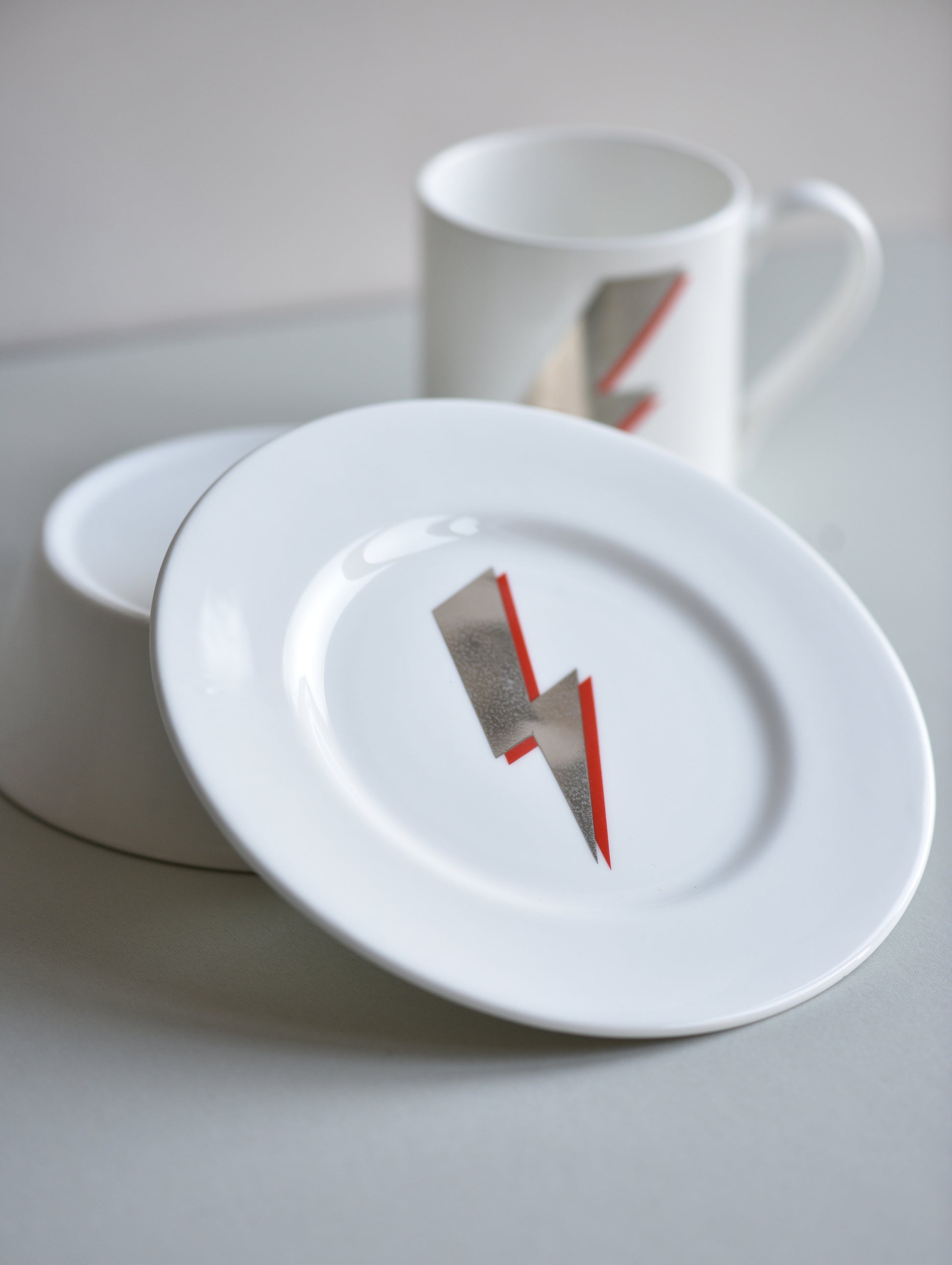 White ceramic plate with a lightning bolt design on a light gray surface