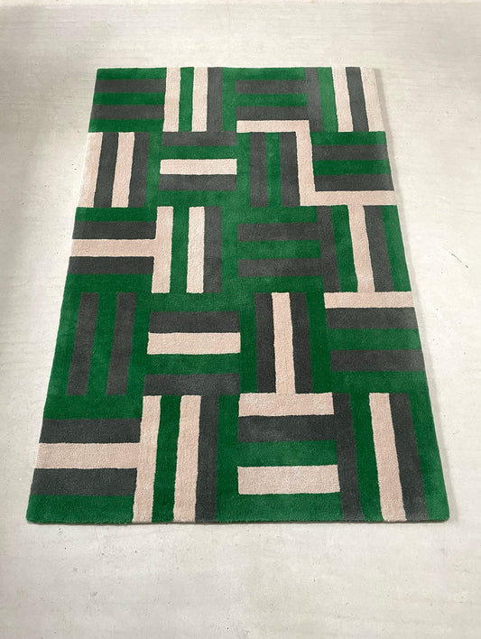 Geometric patterned rug with green, gray, and beige colors on a white background