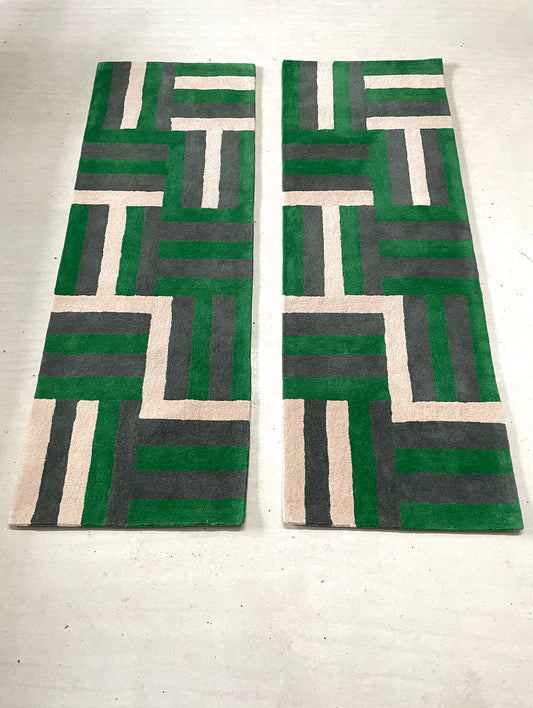 Two geometric-patterned rugs with green, gray, and beige colors on a light background.