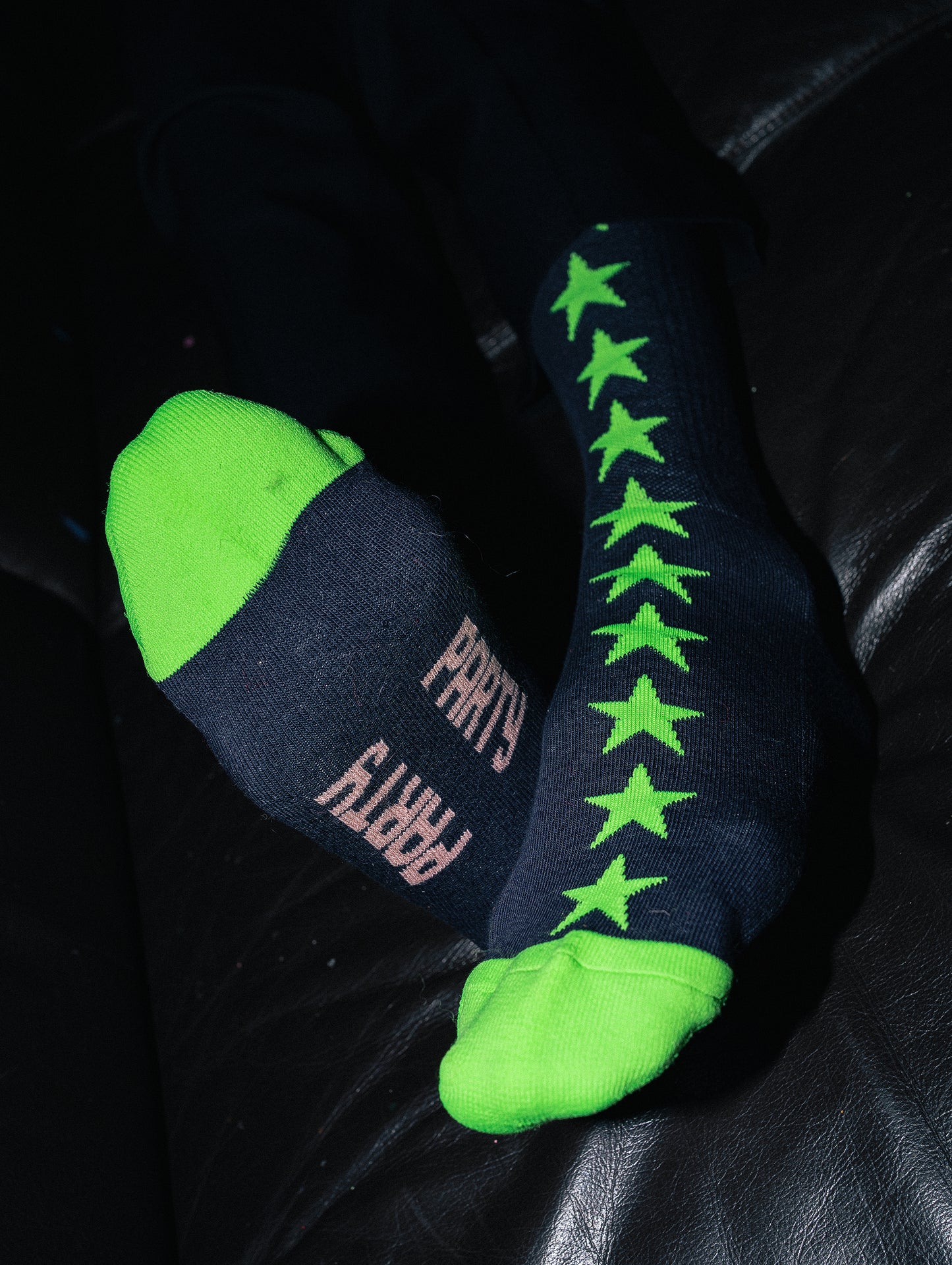 Pair of socks with green stars and text on a dark background