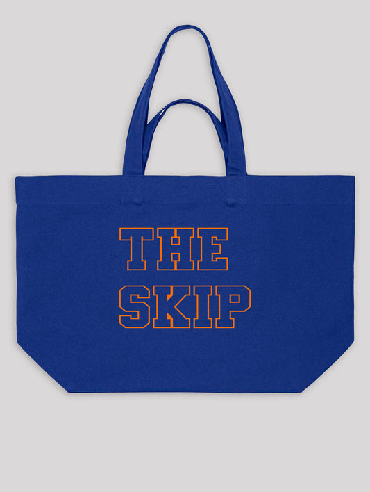 Blue tote bag with 'THE SKIP' text on a gray background