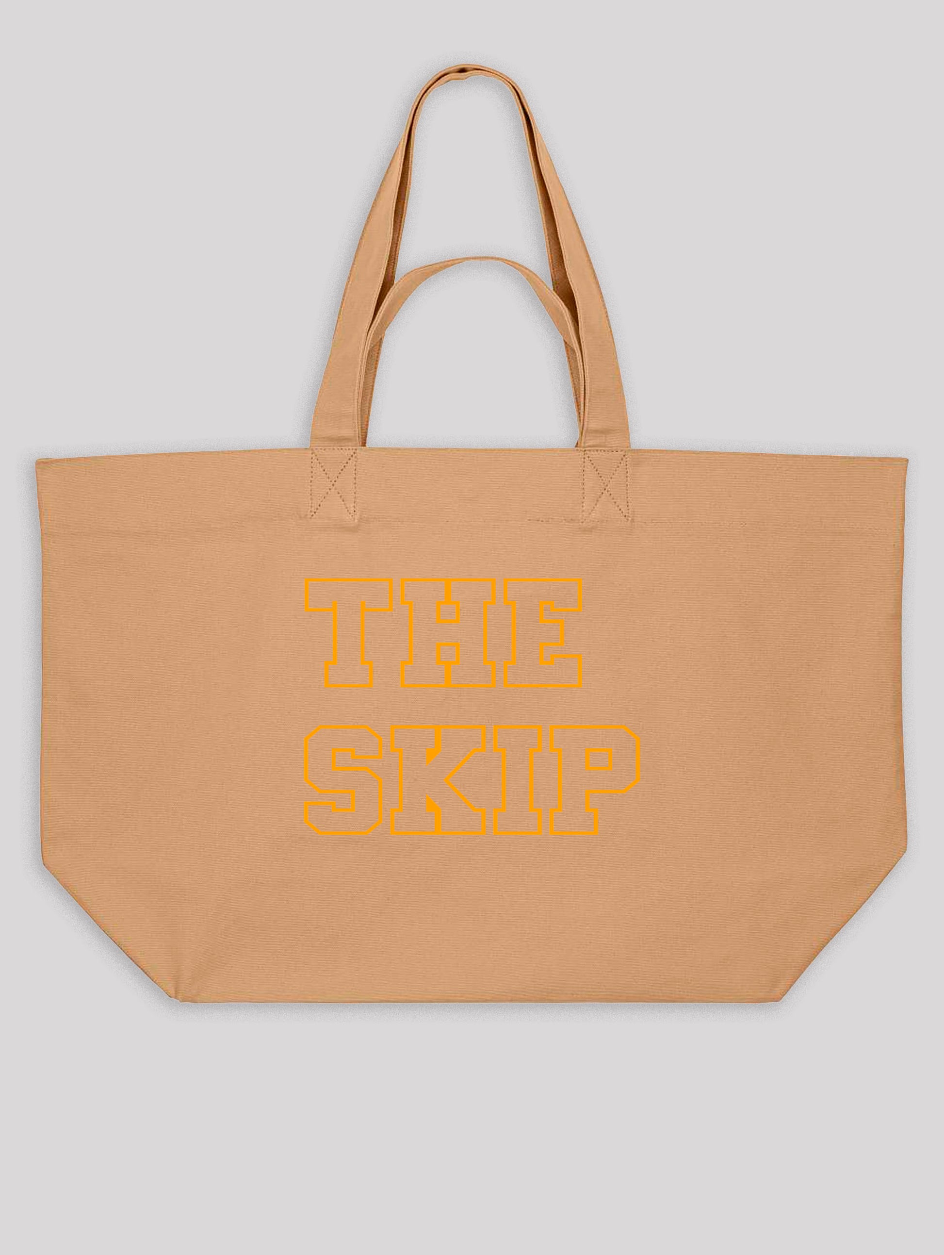 Beige tote bag with 'THE SKIP' text in orange on a light gray background